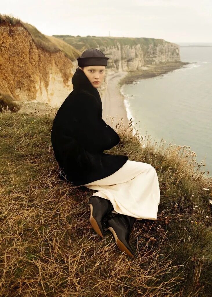 Full-body fashion image outdoors near coastal cliffs